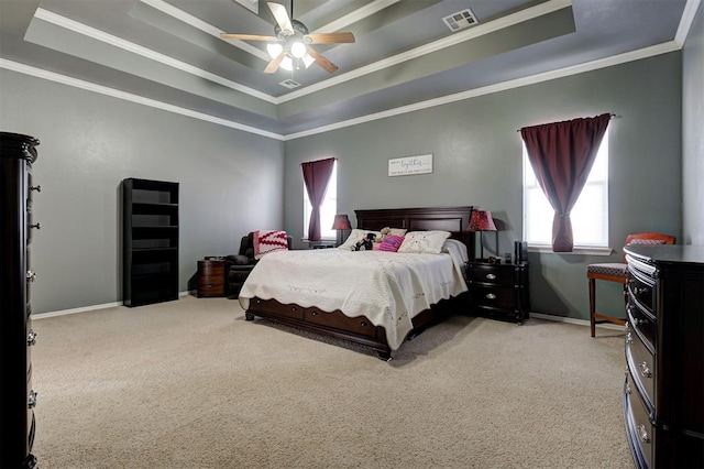 bedroom with crown molding, light colored carpet, a raised ceiling, and ceiling fan