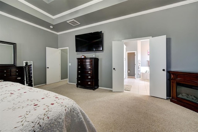 carpeted bedroom with connected bathroom, a towering ceiling, and ornamental molding