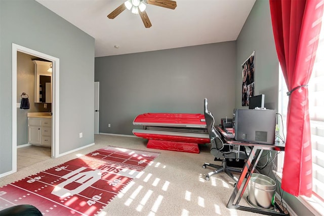 carpeted home office featuring ceiling fan