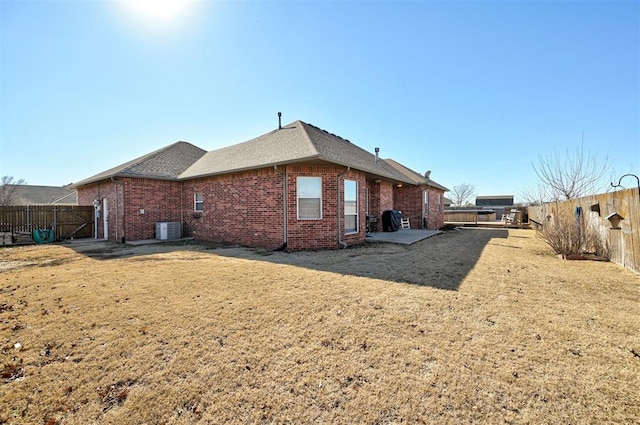 rear view of house with a yard and central AC unit