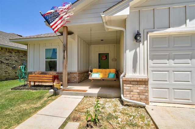 doorway to property featuring a garage and a lawn