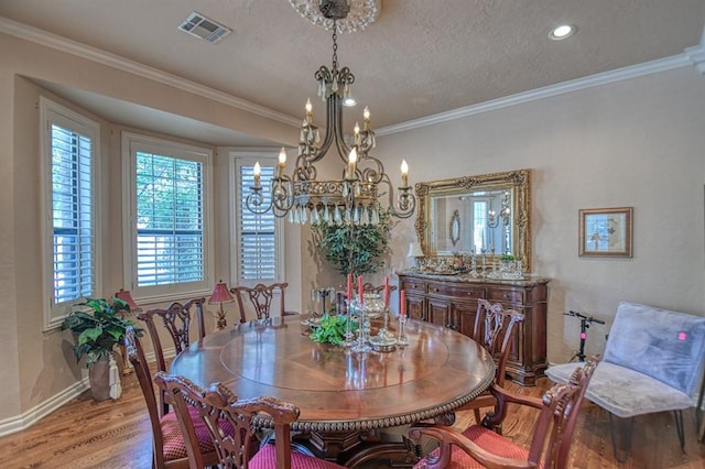 3225 Cotswold Sq, Norman, OK 73072 - dining area featuring ornamental molding, a chandelier, a textured ceiling, and light wood-type flooring