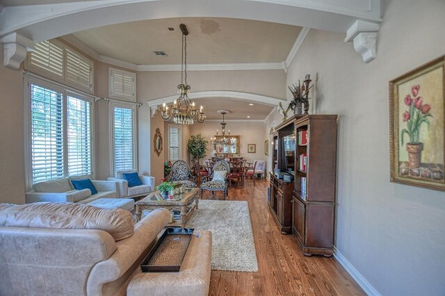 3225 Cotswold Sq, Norman, OK 73072 - living room featuring a notable chandelier, crown molding, and light hardwood / wood-style floors