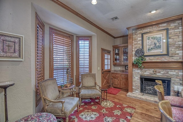 3225 Cotswold Sq, Norman, OK 73072 - living area with a brick fireplace, crown molding, and light wood-type flooring