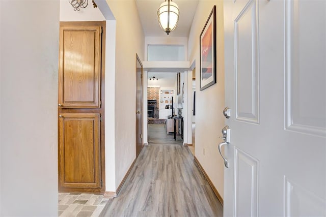 hall with light wood finished floors and baseboards