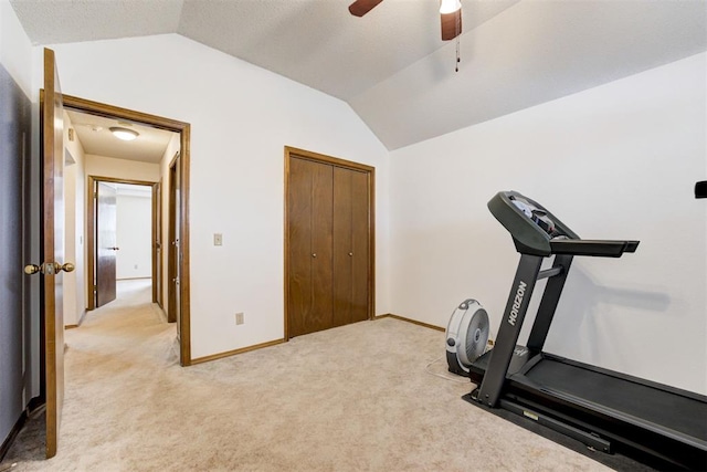 exercise room featuring ceiling fan, baseboards, vaulted ceiling, and light colored carpet