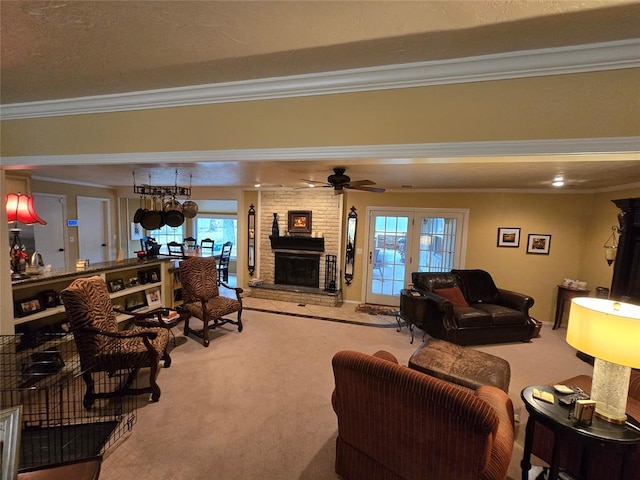 living room featuring ornamental molding, a large fireplace, ceiling fan, and carpet flooring