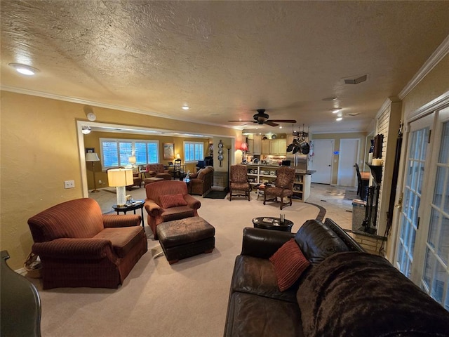 living room with ceiling fan, ornamental molding, carpet floors, and a textured ceiling