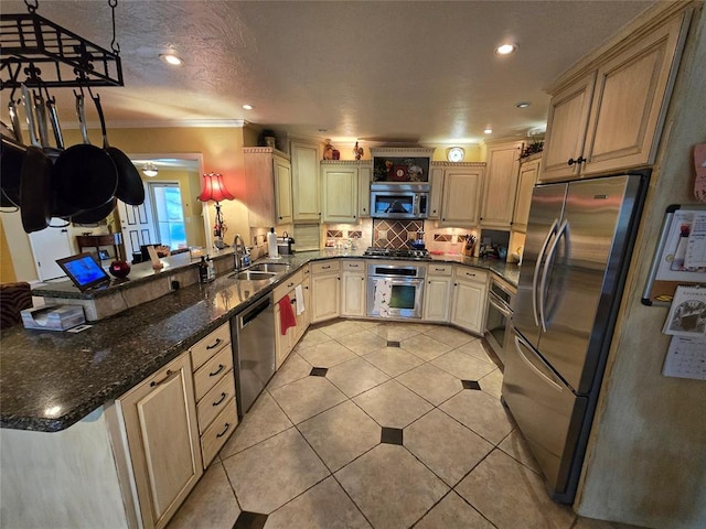 kitchen with sink, dark stone countertops, pendant lighting, stainless steel appliances, and backsplash