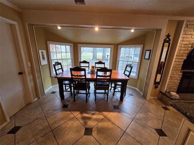 tiled dining area with vaulted ceiling and ornamental molding