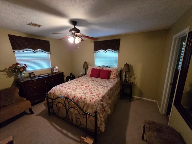 bedroom featuring multiple windows, light colored carpet, and a textured ceiling