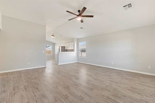 unfurnished living room with ceiling fan, lofted ceiling, and light hardwood / wood-style floors