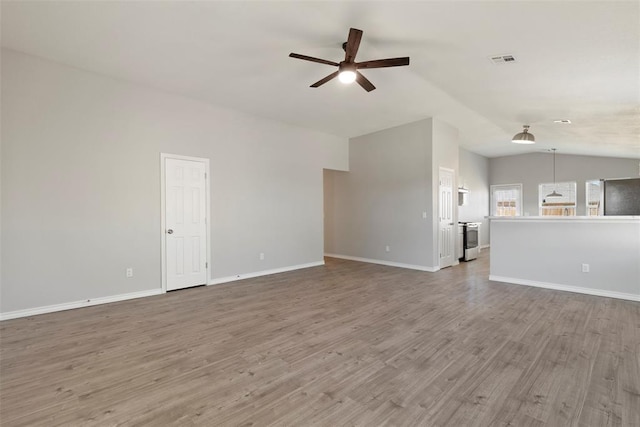 unfurnished living room with wood-type flooring, ceiling fan, and vaulted ceiling