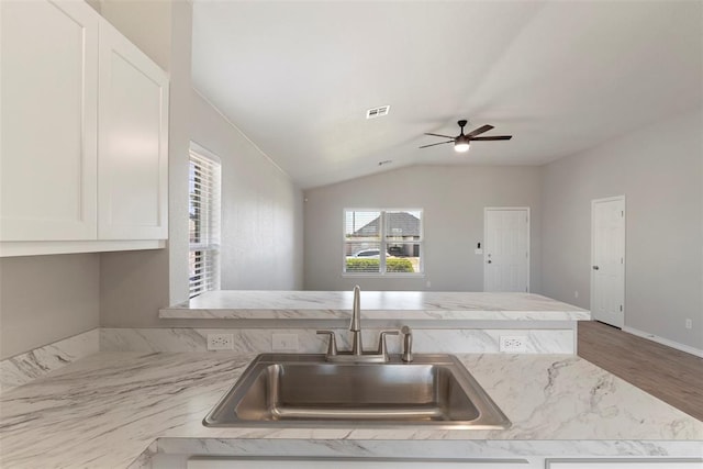 kitchen featuring ceiling fan, lofted ceiling, sink, and hardwood / wood-style floors