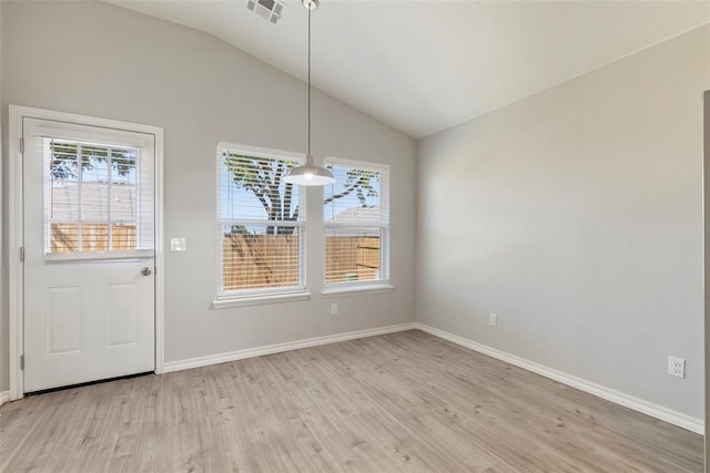 unfurnished dining area with plenty of natural light, light hardwood / wood-style floors, and vaulted ceiling