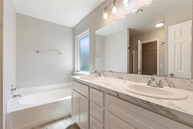 bathroom featuring vanity and a washtub