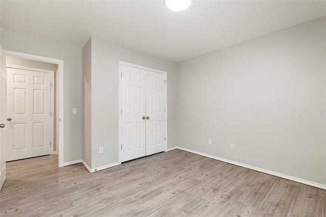 unfurnished bedroom with light hardwood / wood-style floors and a closet