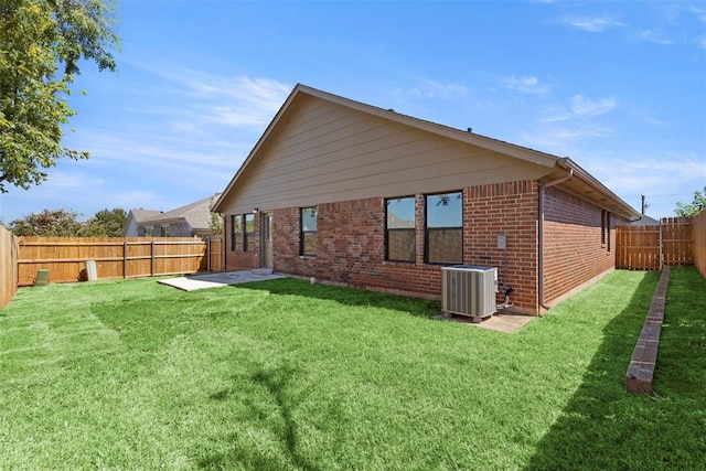 rear view of house featuring a yard and central AC