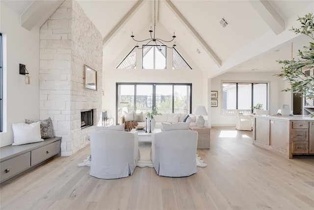 living room with a fireplace, light hardwood / wood-style flooring, high vaulted ceiling, and beamed ceiling