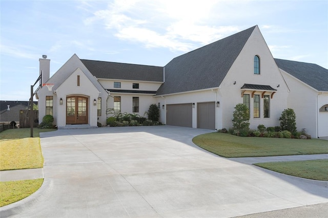 french country inspired facade with french doors and a front yard