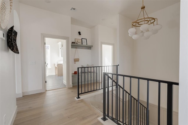 hall featuring a notable chandelier and light hardwood / wood-style floors