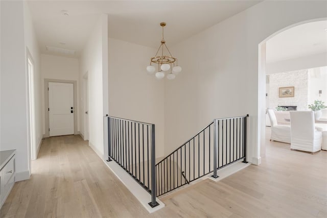 hall with an inviting chandelier and light hardwood / wood-style floors