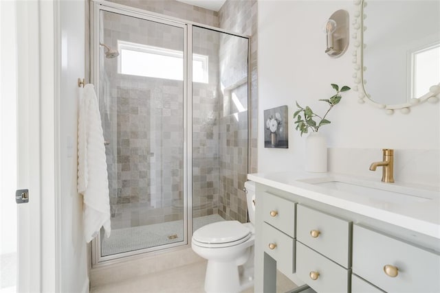 bathroom featuring vanity, tile patterned flooring, toilet, and walk in shower