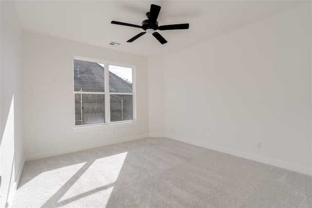 spare room with ceiling fan and light carpet