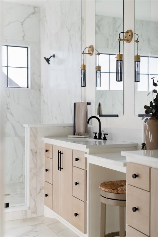 bathroom with vanity, a shower with shower door, and tile walls