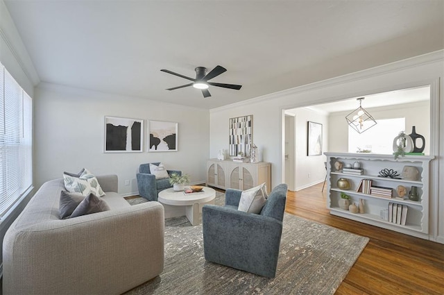 living room featuring dark hardwood / wood-style flooring, ornamental molding, and ceiling fan