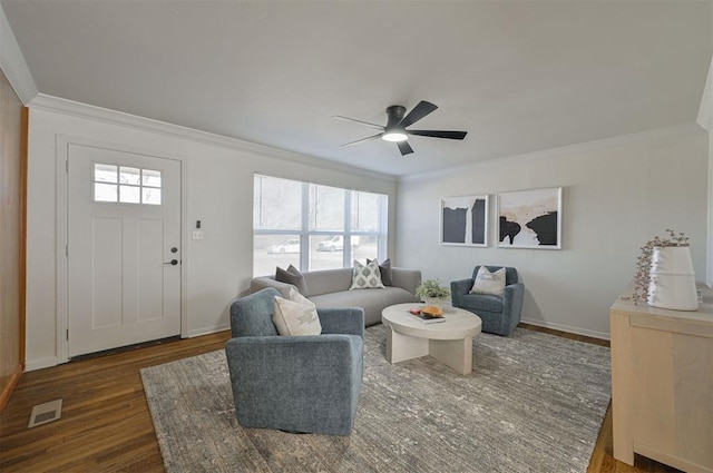 living room featuring ceiling fan, crown molding, dark wood-type flooring, and a healthy amount of sunlight