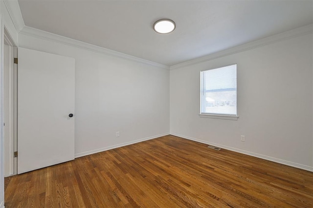 empty room featuring crown molding and hardwood / wood-style flooring