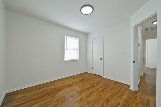 spare room featuring wood-type flooring