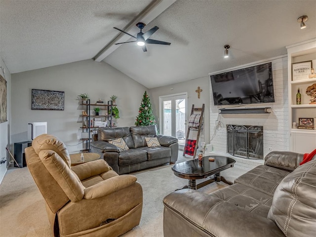 carpeted living room with ceiling fan, a brick fireplace, lofted ceiling with beams, and a textured ceiling