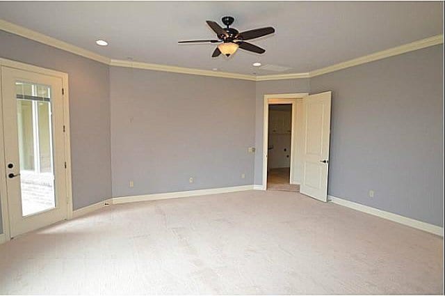 carpeted empty room featuring crown molding and ceiling fan