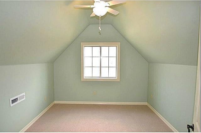 additional living space featuring vaulted ceiling, carpet floors, and ceiling fan