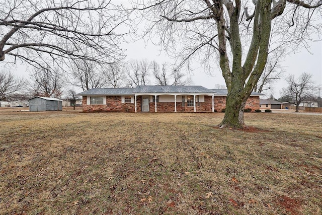 single story home featuring a storage shed and a front lawn