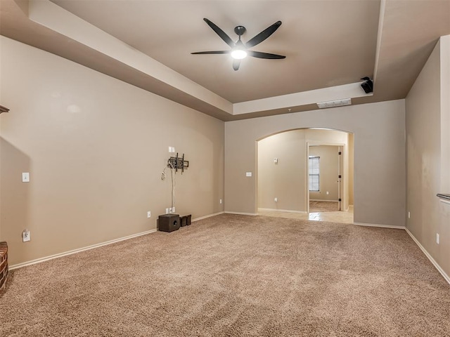 spare room featuring ceiling fan, a raised ceiling, and carpet floors