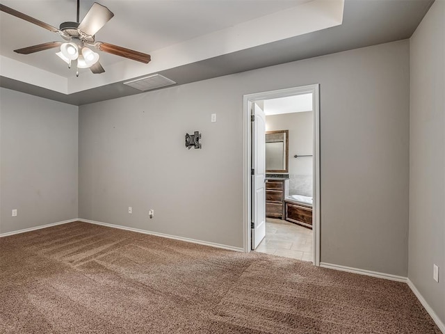 empty room featuring light colored carpet, ceiling fan, and a tray ceiling