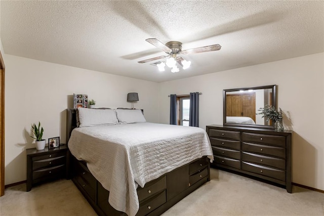 carpeted bedroom featuring a textured ceiling and ceiling fan