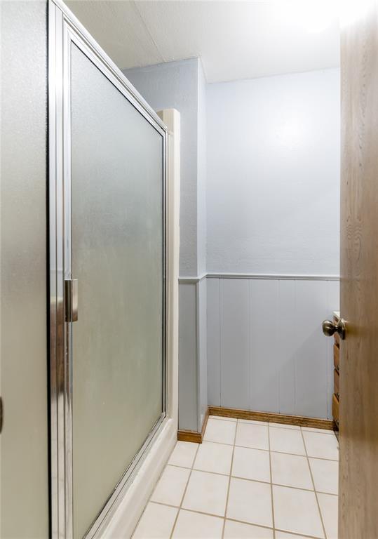 bathroom with tile patterned floors and a shower with shower door