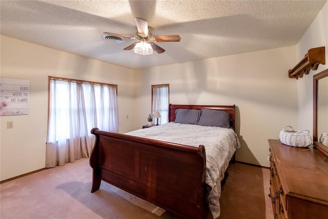 bedroom with light colored carpet, a textured ceiling, and ceiling fan