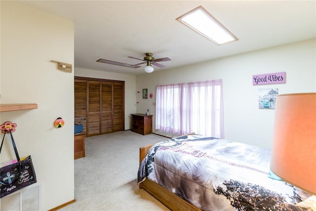 carpeted bedroom with a closet and ceiling fan