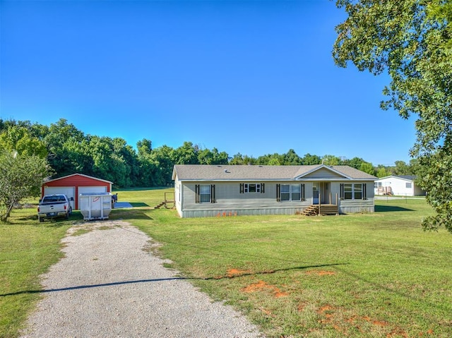 view of front of property with a garage, an outdoor structure, and a front yard