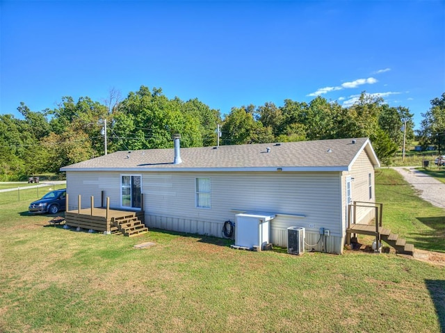 back of property with a lawn, a deck, and central air condition unit