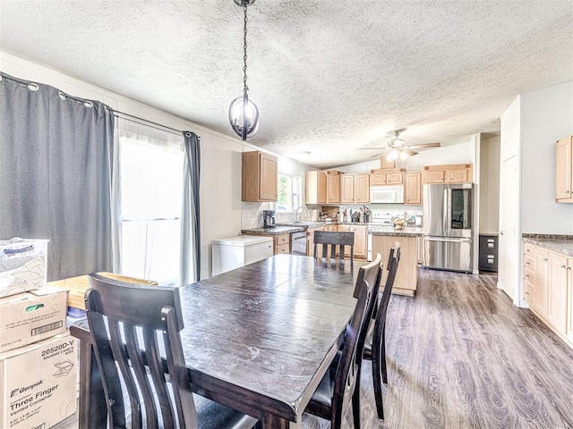 dining area featuring hardwood / wood-style flooring, ceiling fan, lofted ceiling, and a textured ceiling