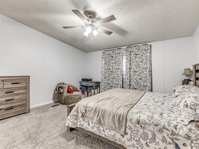 carpeted bedroom featuring ceiling fan and a textured ceiling