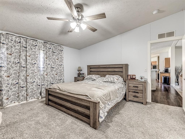 carpeted bedroom with ceiling fan and a textured ceiling