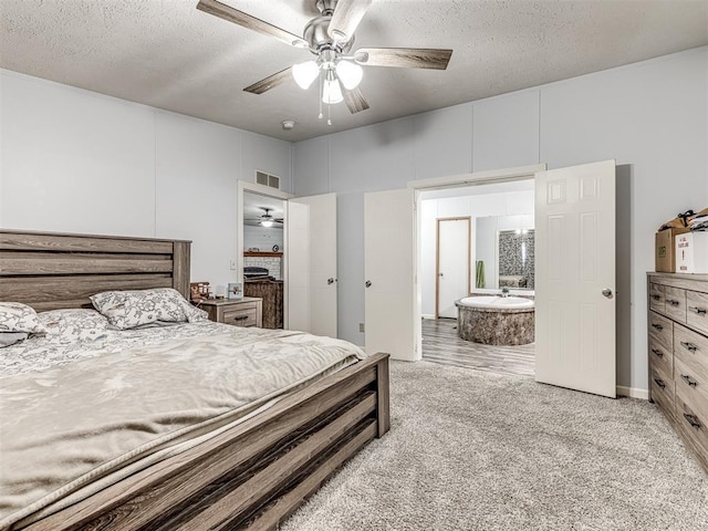 bedroom featuring ceiling fan, light colored carpet, and a textured ceiling