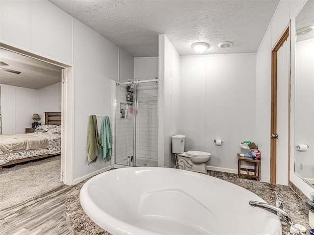 bathroom featuring walk in shower, wood-type flooring, toilet, and a textured ceiling